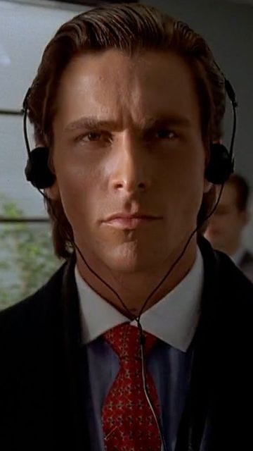 Patrick Bateman with headphones on staring directly into your soul