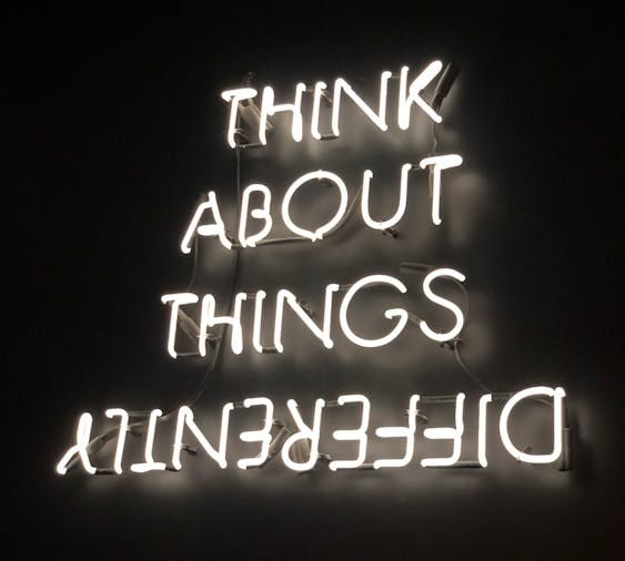 Free A glowing neon sign displaying an upside-down motivational quote against a dark background. Stock Photo