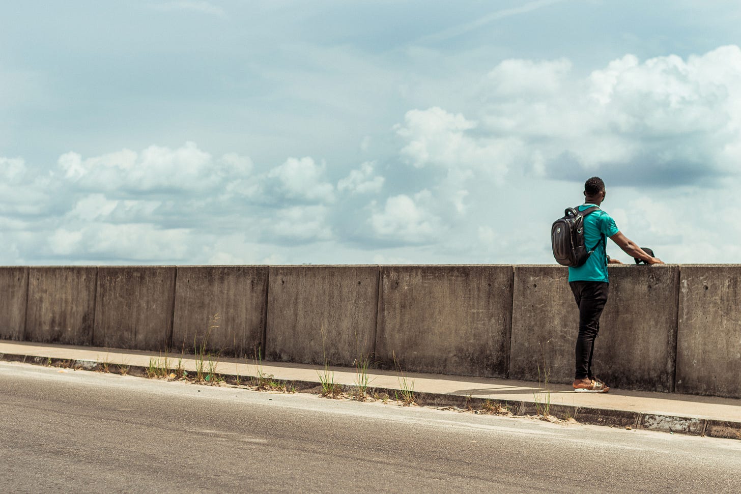 a backpack traveler standing on a bridge taken by myashgarage
