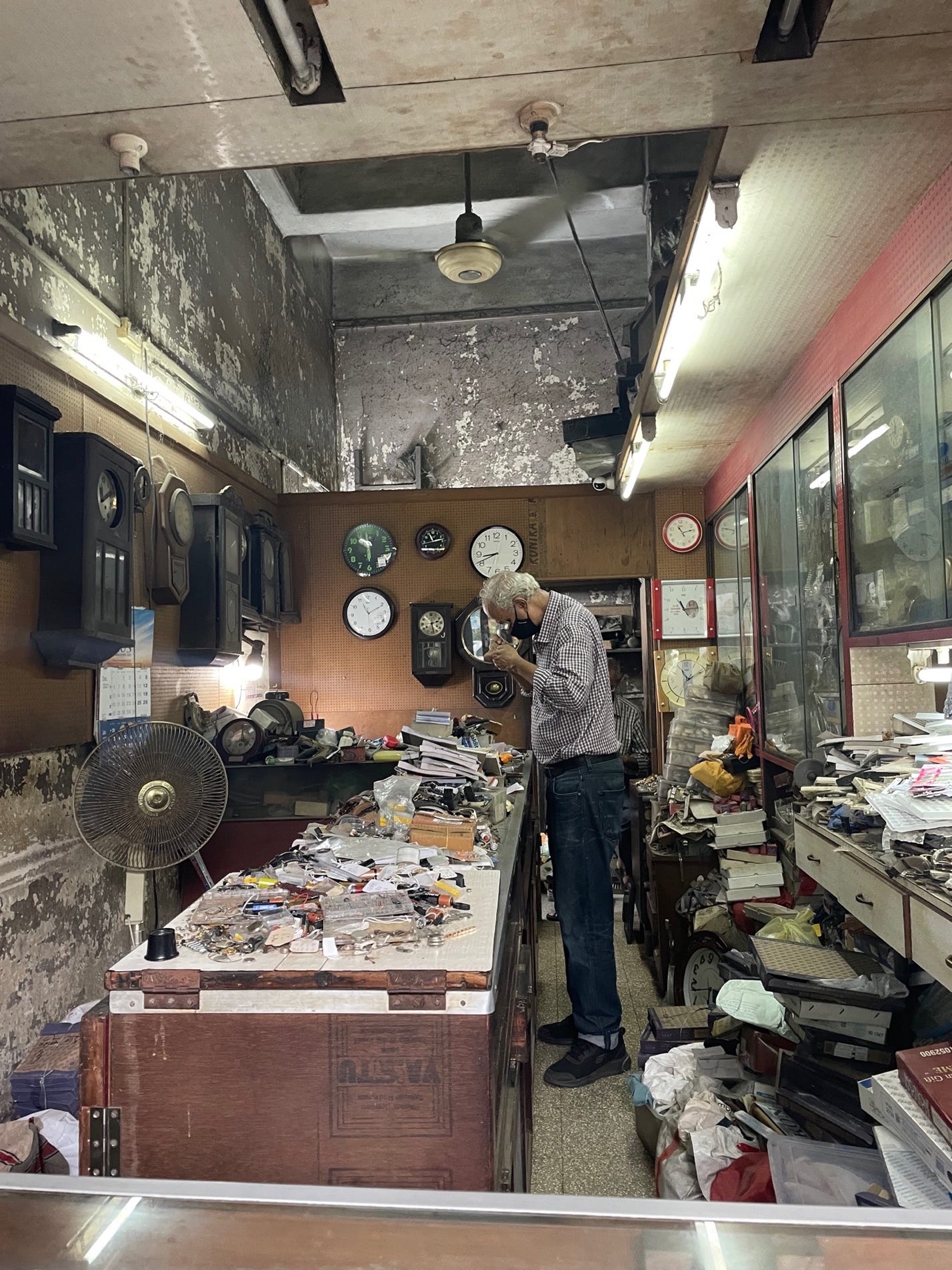 A person standing in a room with a table full of objects

Description automatically generated