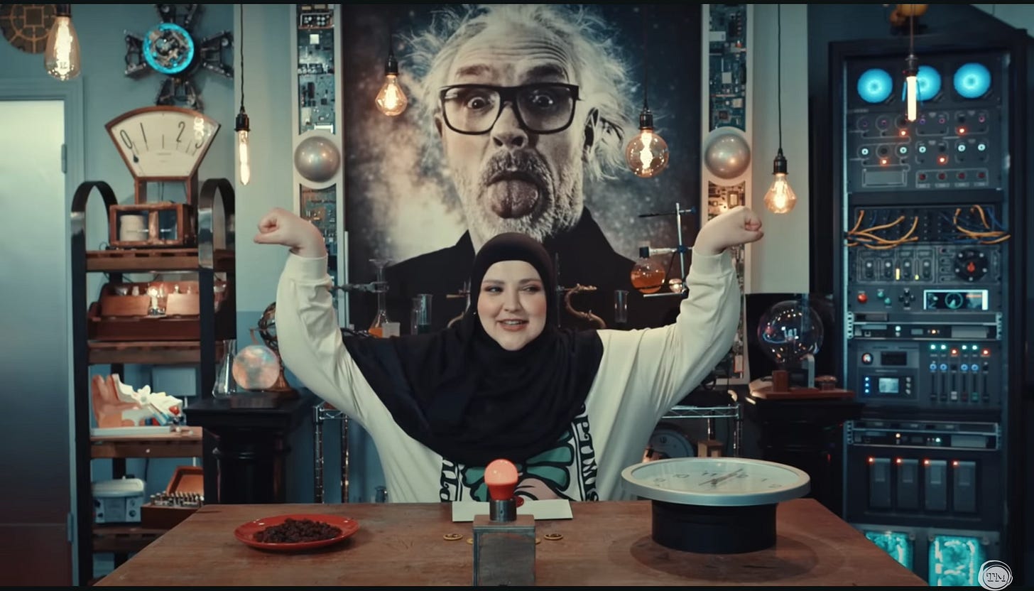 Fatiha El-Ghorri, wearing a hijab and a long-sleeved T-shirt, strikes a muscle pose.