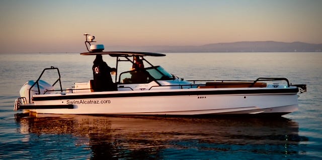 Swim Alcatraz Axopar escort vessel on calm waters, designed exclusively for open water swimming support, featuring advanced marine electronics and safety equipment. Swim Alcatraz Axopar escort vessel on calm waters, designed exclusively for open water swimming support, featuring advanced marine electronics and safety equipment.
