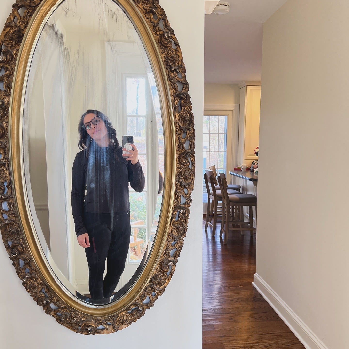 woman taking a selfie in an antique oval mirror