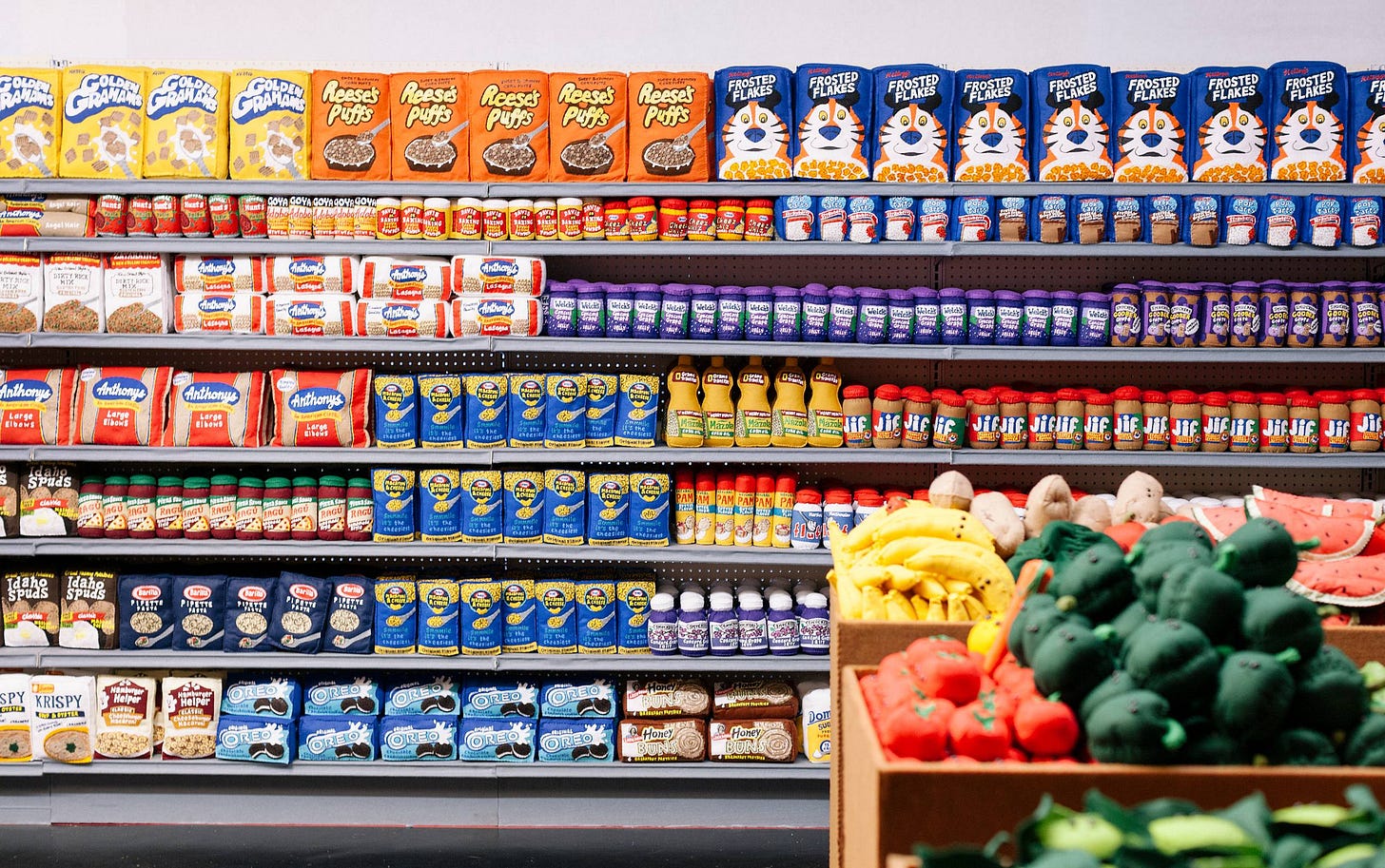 Supermarket aisle with shelves of packaged foods and a box of plush fruits and vegetables. Supermarket aisle with shelves of packaged foods and a box of plush fruits and vegetables.
