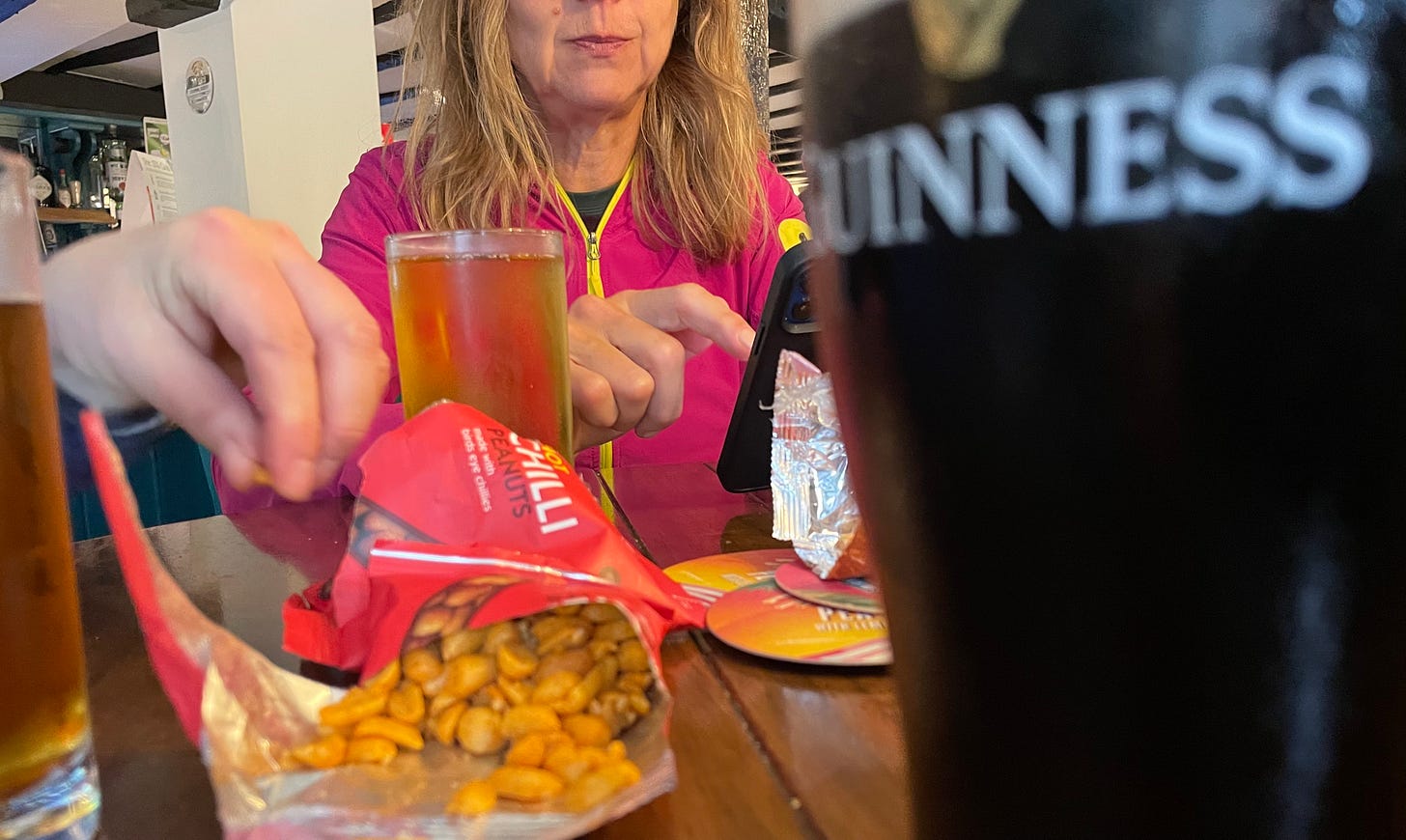 In a pub with drinks and peanuts on the table