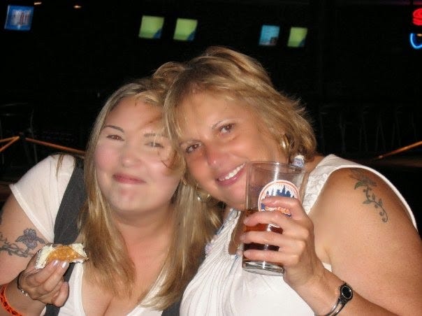 2009 photo of Mom & me, big smiles, a drink in her hand, a mini cannoli in mine