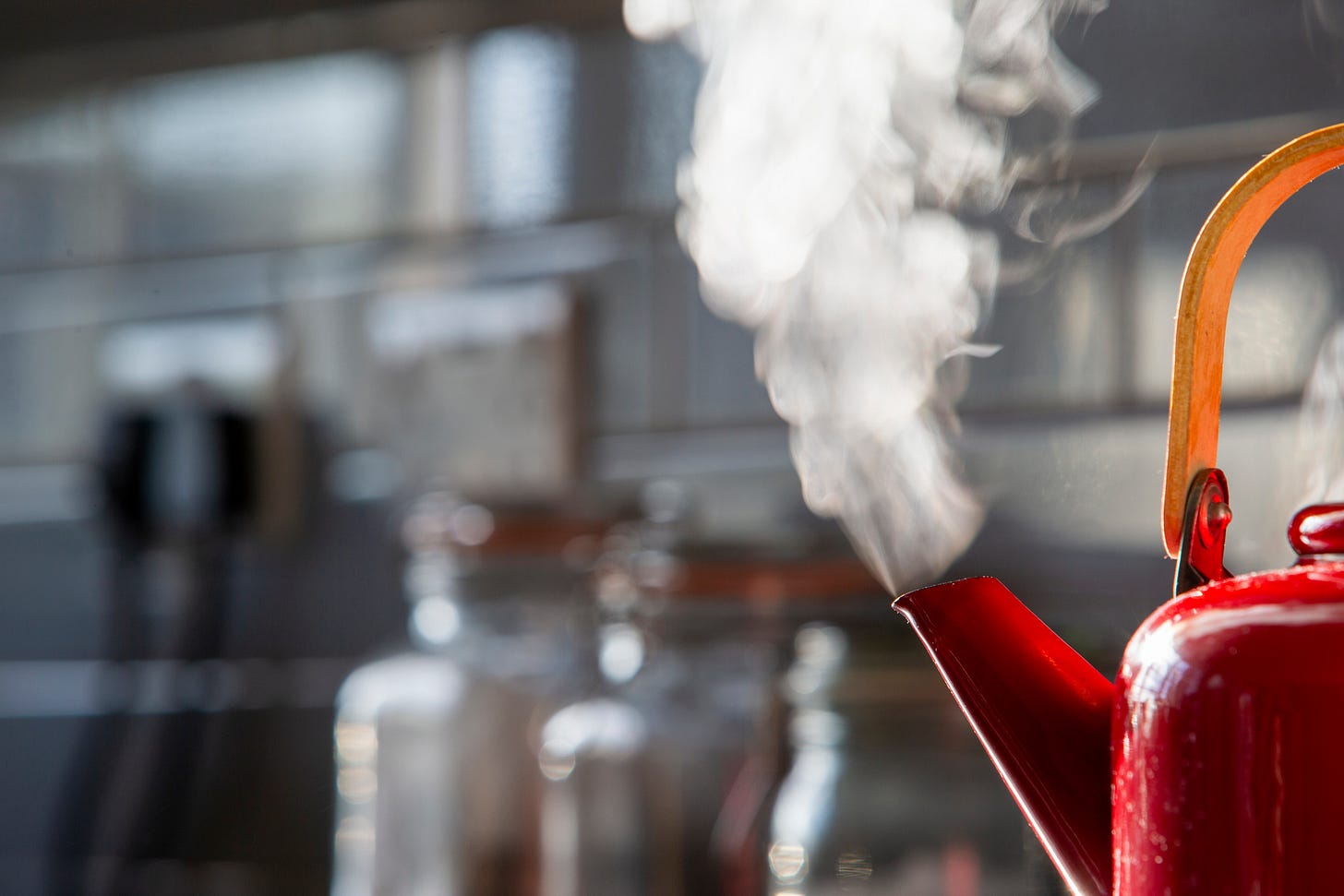 Red tea kettle with steam emanating from the spout
