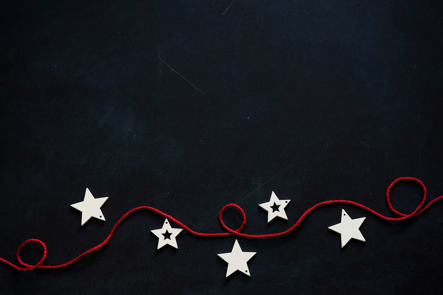 5 stars on a black background with a red string looping between them. 5 stars on a black background with a red string looping between them.