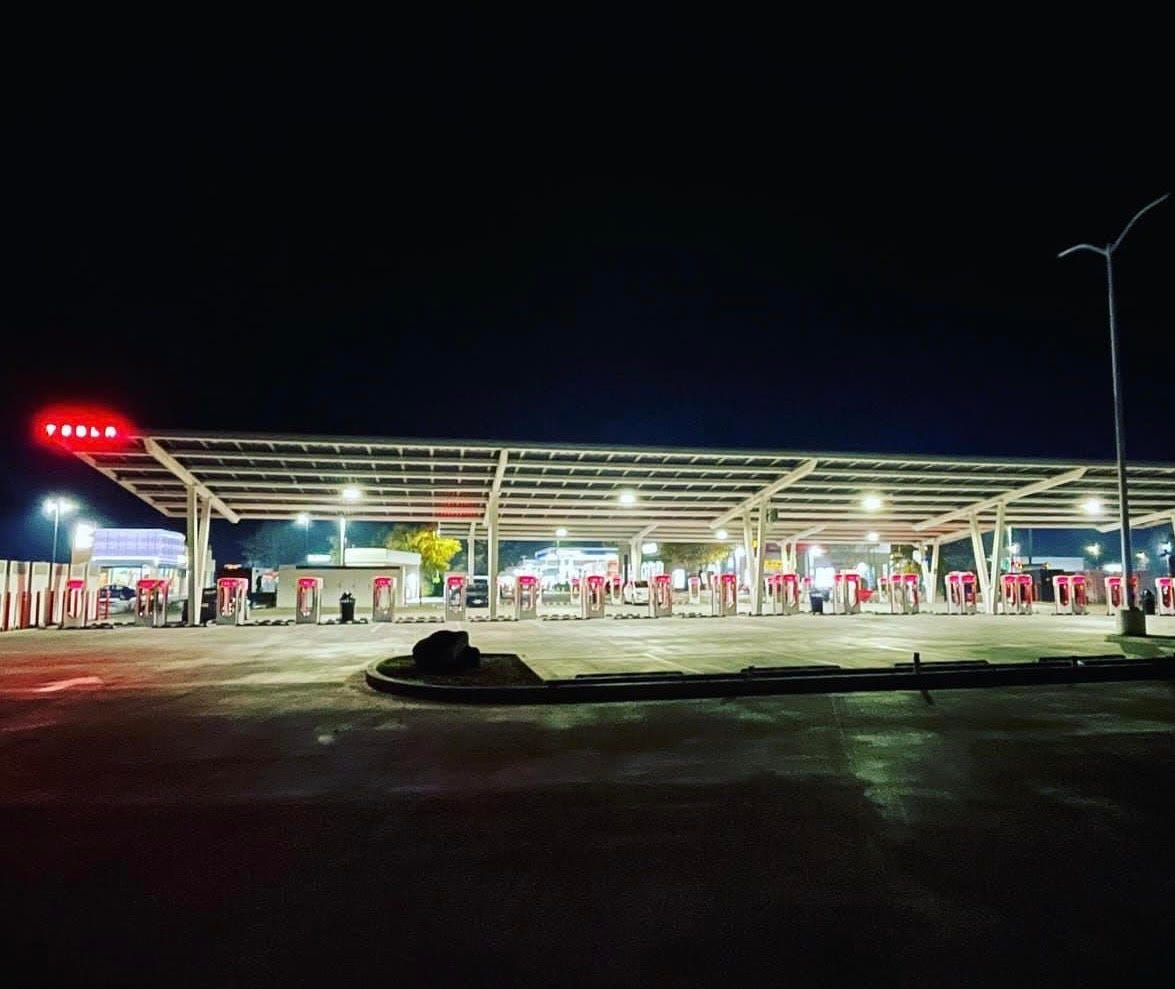 A Tesla electric car charging station lit up at night