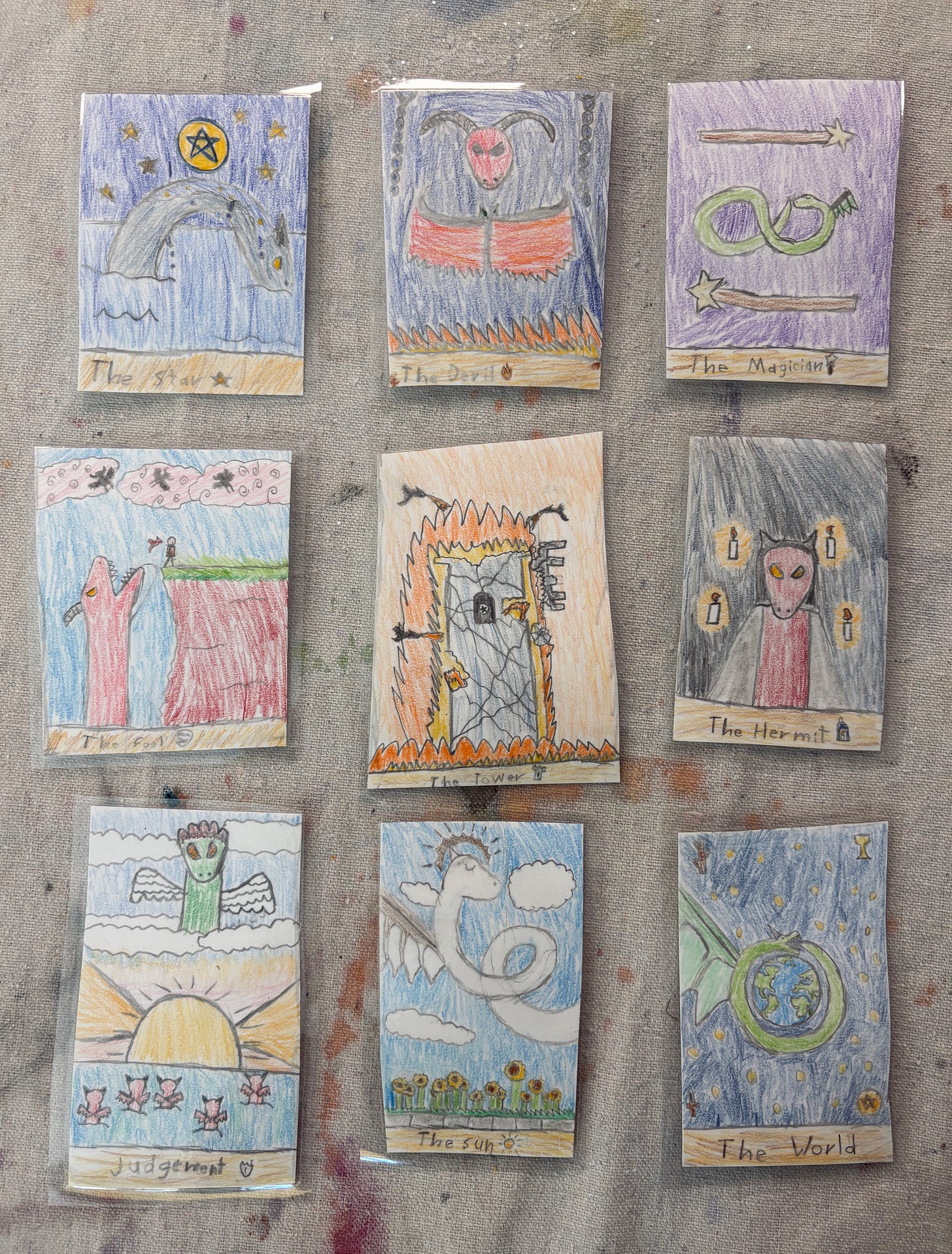Tarot cards with a prominent dragon on each card, hand-drawn in color pencil.