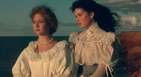 This may contain: two women standing next to each other near the ocean This may contain: two women standing next to each other near the ocean