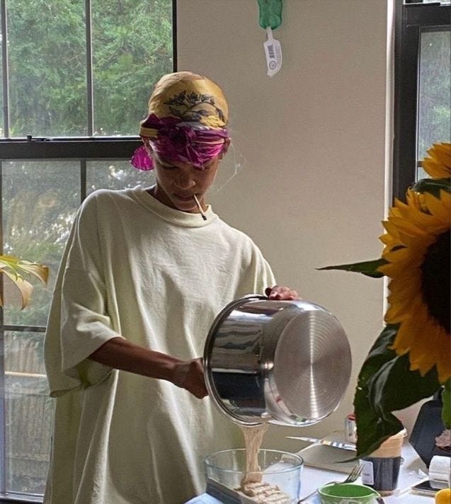 This may contain: a woman is pouring something into a bowl on a table next to a sunflower