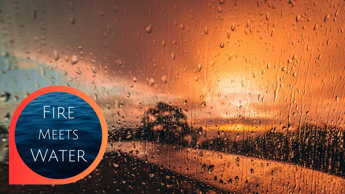 Fire meets water: through a rain-speckled window, the clouds are on fire with a sunset