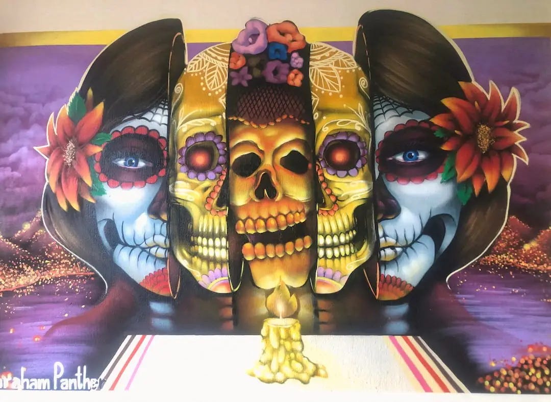 Street art in Guadalajara - a decorated woman's face is split in two to show skulls inside