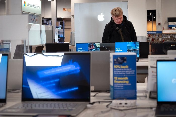 A customer shopping for computers at a consumer electronics store.