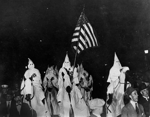 KKK members ride horses during a parade through Tulsa, OK streets