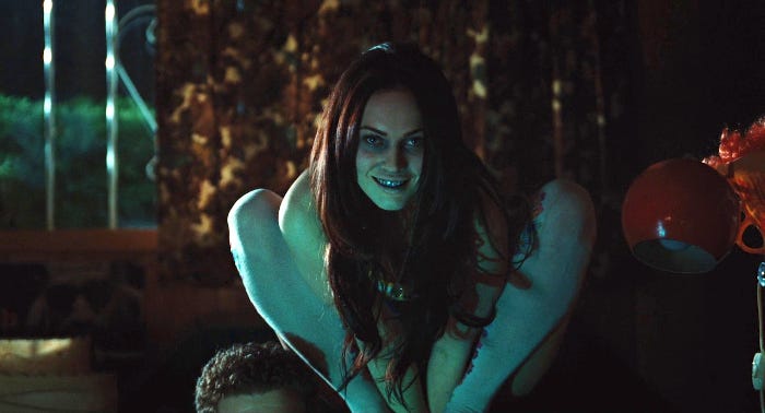 Jennifer Check crouched creepily in the dark with the dead football boy next to her