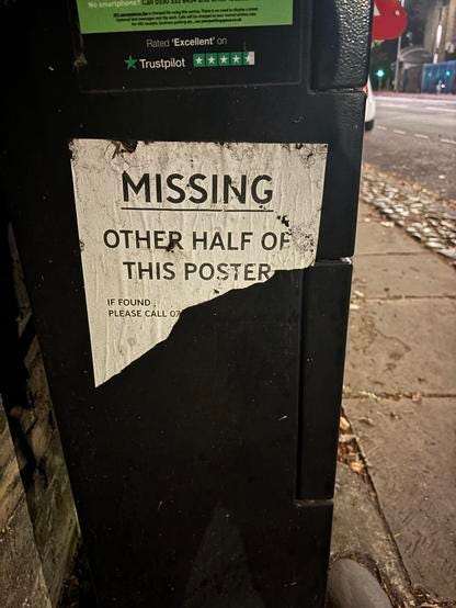 A poster on the side of a parking meter on a street. It's torn in half. The visible part reads: "missing : other half of this poster. If found please call 0" and the rest of the number is on the torn away part.