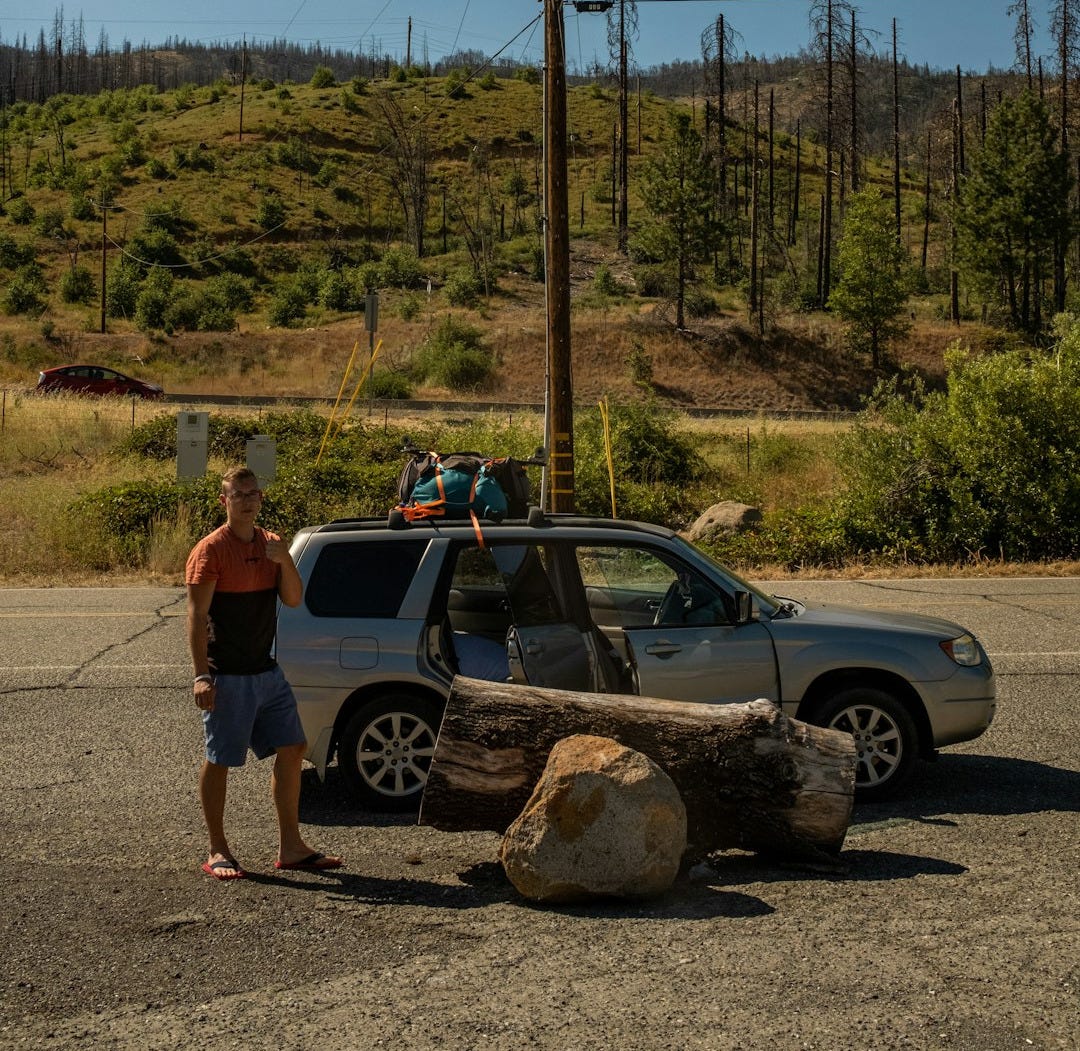 a person standing next to a car a person standing next to a car