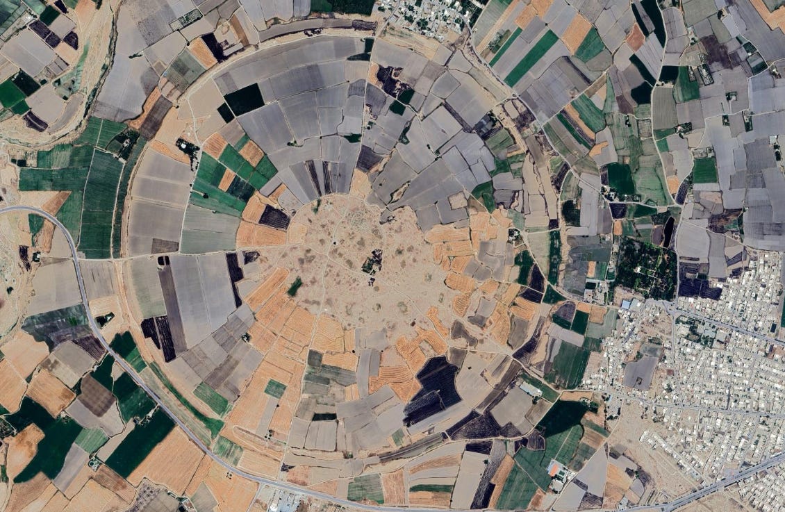 Aerial satellite view of the ancient city of Gūr in Iran, showing its perfectly circular outline in the arid landscape, surrounded by modern farmland.