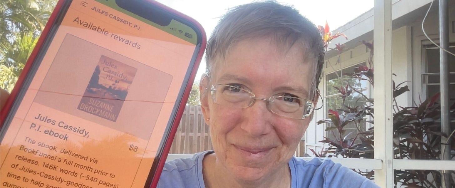 Your author, Suz Brockmann, a tired-looking older white woman with short fair hair and glasses in a blue shirt, smiles as she holds up her iPhone with the Kickstarter page focusing on the ebook “reward” for her latest book, Jules Cassidy, P.I. Text on her phone reads: Available rewards, with the cover art for the book below. The cover art shows a reddish-tinged evening sky and a road in a tired-looking Los Angeles Valley neighborhood where the small figures of two men, one large, one smaller, run across the street. Palm trees and electrical poles are silhouette against the sunset. Beneath the cover art it reads: Jules Cassidy, P.I. ebook $8. The ebook, delivered via BookFunnel a full month prior to release. 146K words (~540 pages) of Jules Cassidy goodness.