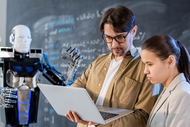 Teacher of computer technologies or programmer making presentation of automation robot operated with help of special software
