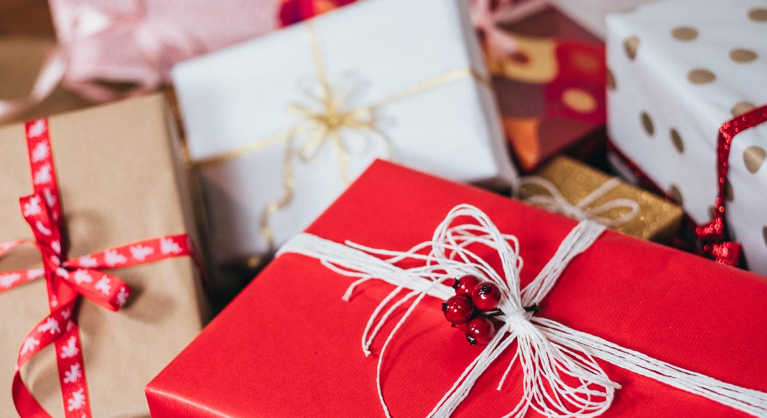 A collection of presents wrapped in brown, white, and red paper, wrapped in ribbons