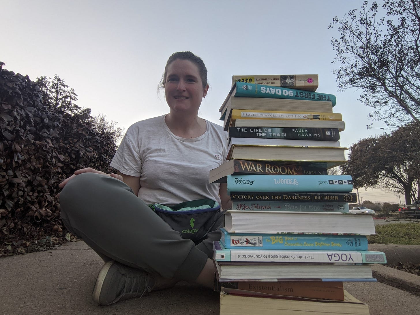 PIcture of author next to stack of books