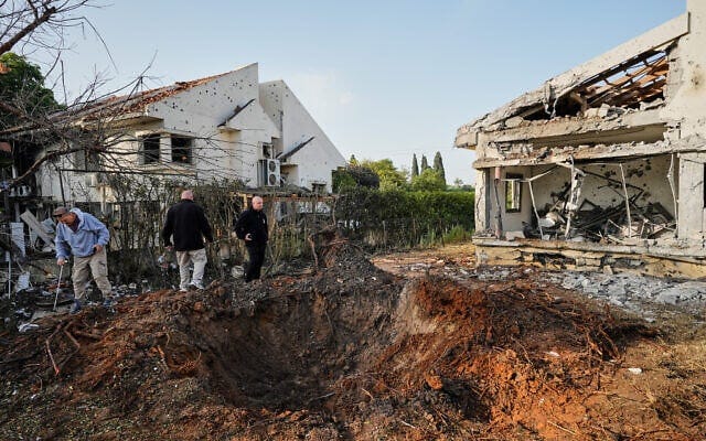 People inspect homes damaged by a rocket fired by Hezbollah from Lebanon, in Haniel in central Israel, March 12, 2026. (AP Photo/Baz Ratner)