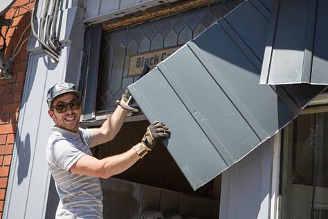 revealing the old hand painted sign at Black Cat Artspace