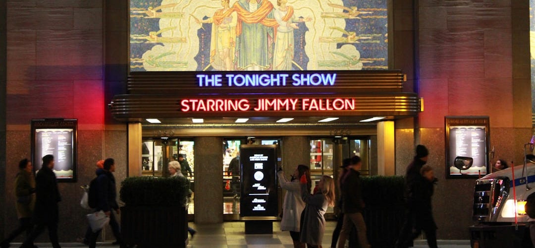 a crowd of people walking in front of a building