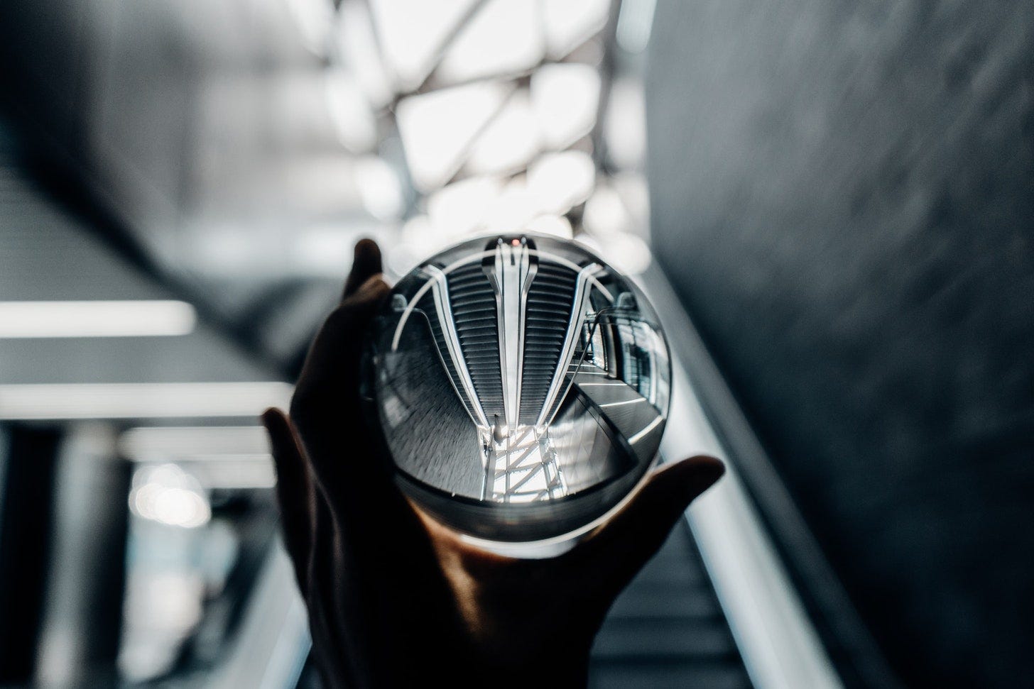 Black and white photo of a hand holding a glass ball reflecting the image of a staircase, Black and white photo of a hand holding a glass ball reflecting the image of a staircase,