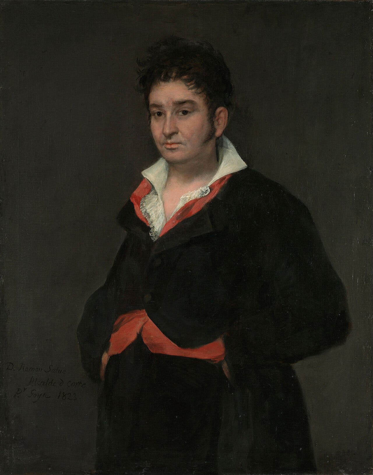 A judge in dark clothes with an open collar, seated against a plain background A judge in dark clothes with an open collar, seated against a plain background