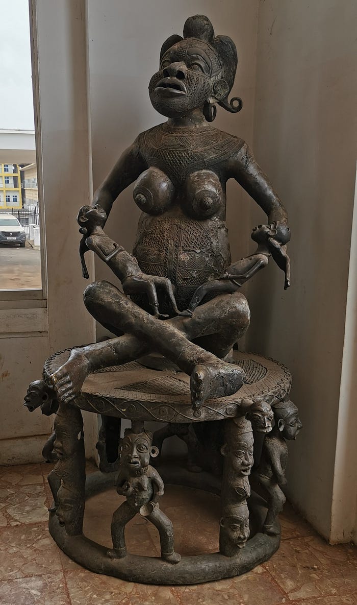 Wooden statue of a naked woman, face in pain, holding two babies in her lap. Wooden statue of a naked woman, face in pain, holding two babies in her lap.