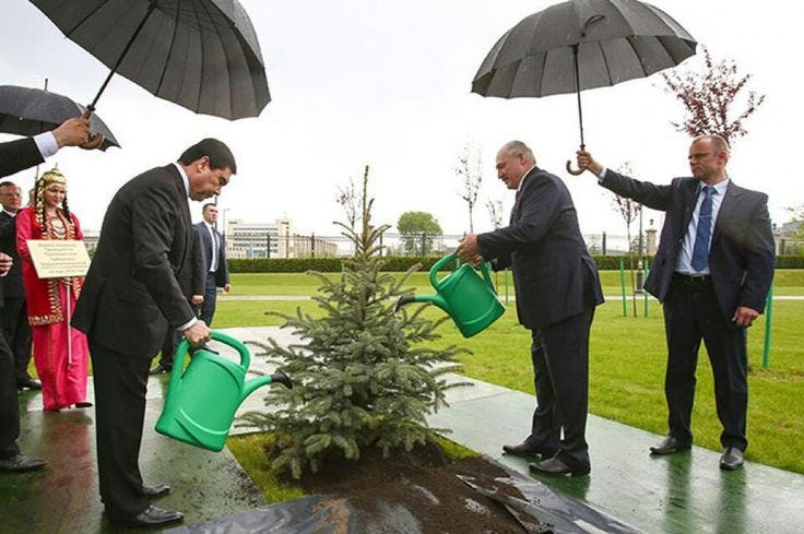 This may contain: three men are watering plants in the rain, and one man is holding an umbrella This may contain: three men are watering plants in the rain, and one man is holding an umbrella
