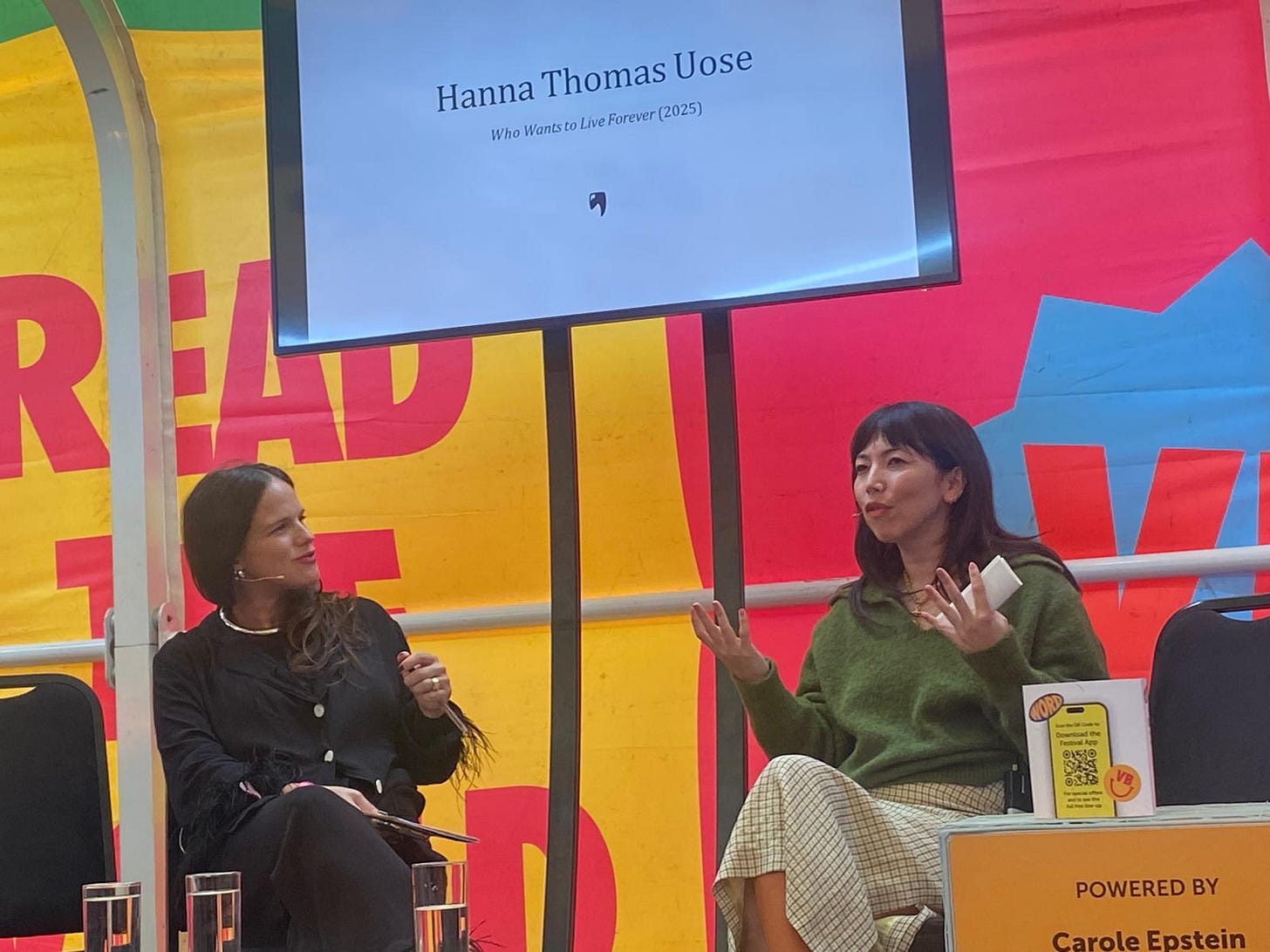 Me and Romilly sitting on the colourful Voice Box stage at Cheltenham Literary Festival