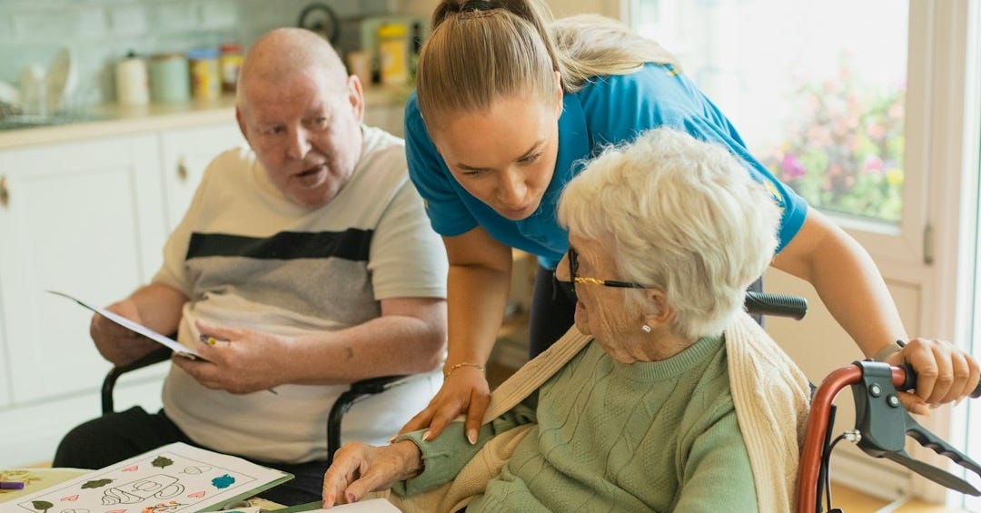 Caregiver assisting elderly couple with coloring Caregiver assisting elderly couple with coloring