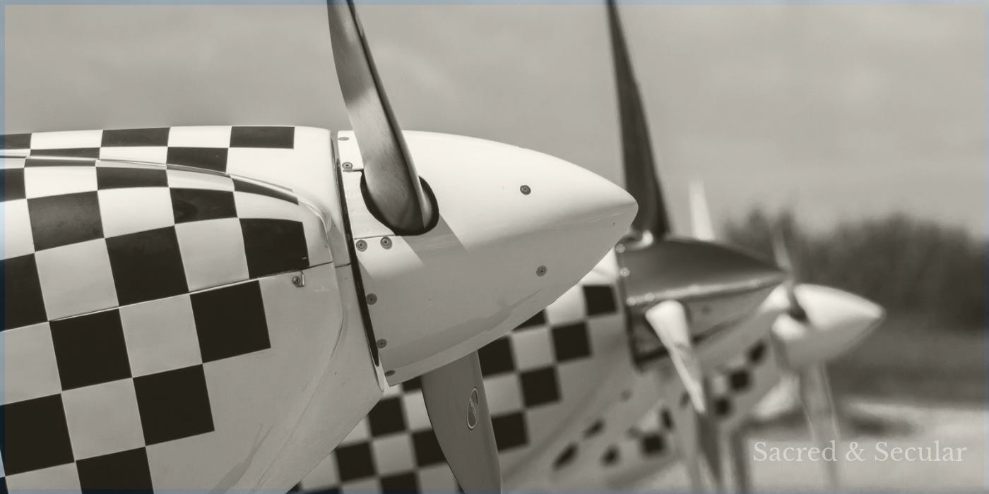 A propeller aircraft parked on an airfield, its propeller motionless.