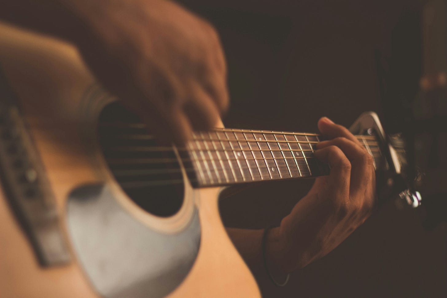 two hands playing a guitar