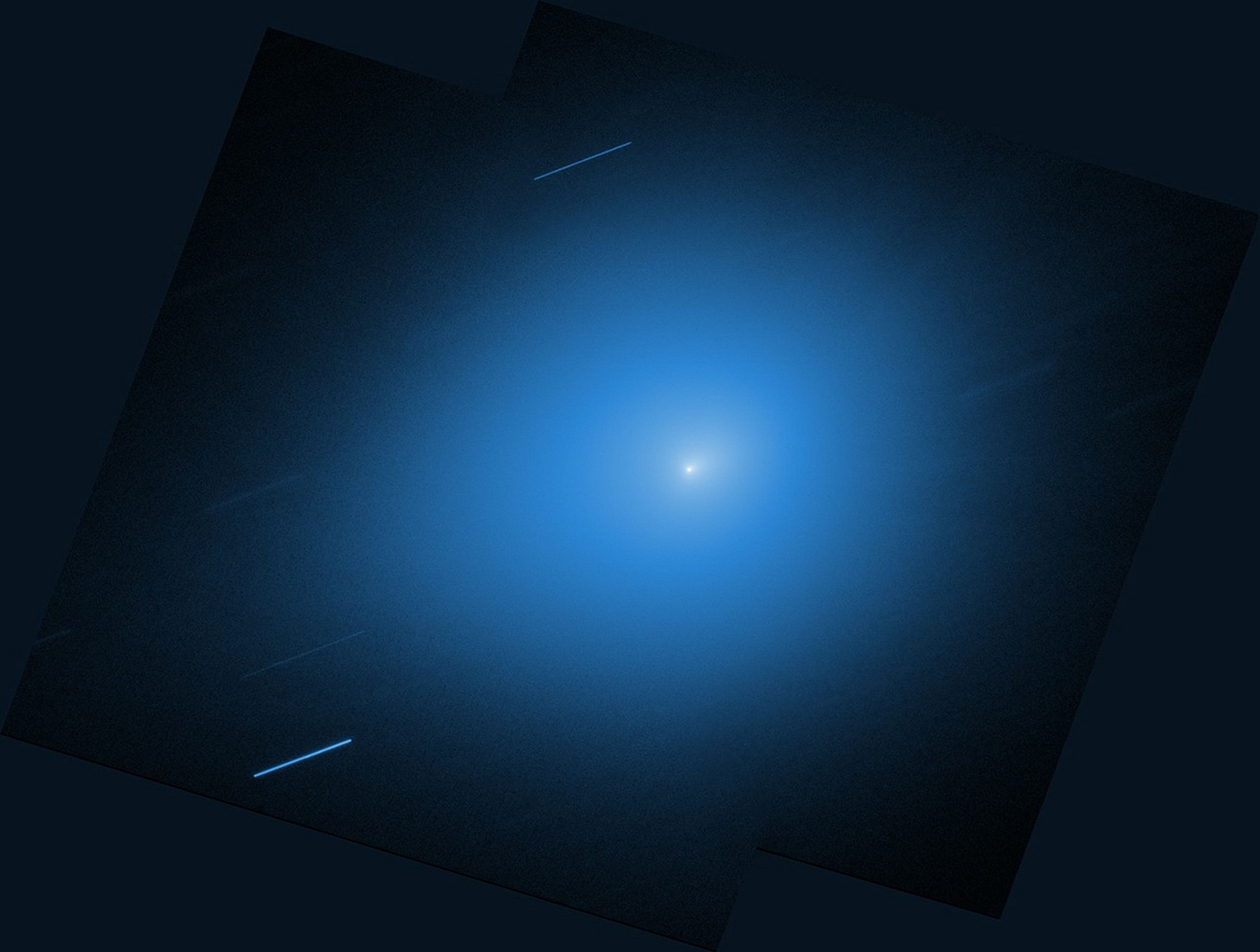 An image from NASA’s Hubble Space Telescope showing the interstellar comet 3I/ATLAS. The comet is a small white dot in the center of the image, with a light blue halo of light that takes up most of the image. Other stars are shown streaking across the image as diagonal blue-white lines. An image from NASA’s Hubble Space Telescope showing the interstellar comet 3I/ATLAS. The comet is a small white dot in the center of the image, with a light blue halo of light that takes up most of the image. Other stars are shown streaking across the image as diagonal blue-white lines.