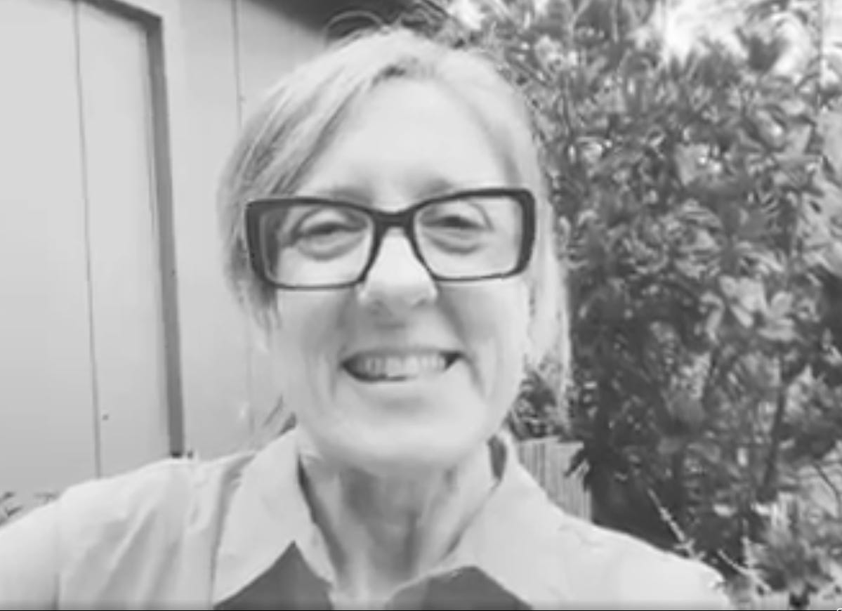 Black and white image of Jax with a big smile outsider her house in Blackwood.