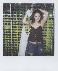 polaroid of pale teenager in a tank top standing in front of a display of sunglasses polaroid of pale teenager in a tank top standing in front of a display of sunglasses