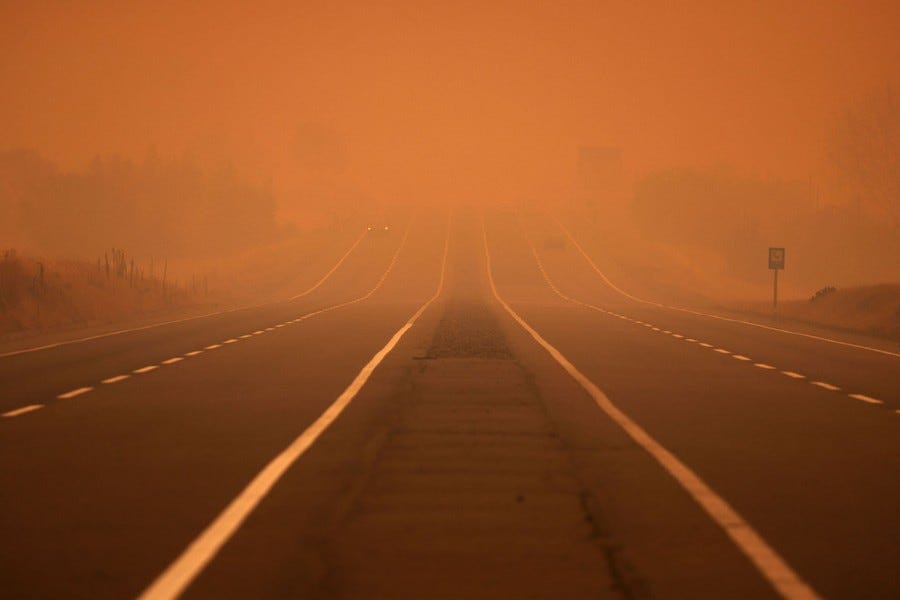 Smoke covers a road, coloring the sky orange. Smoke covers a road, coloring the sky orange.