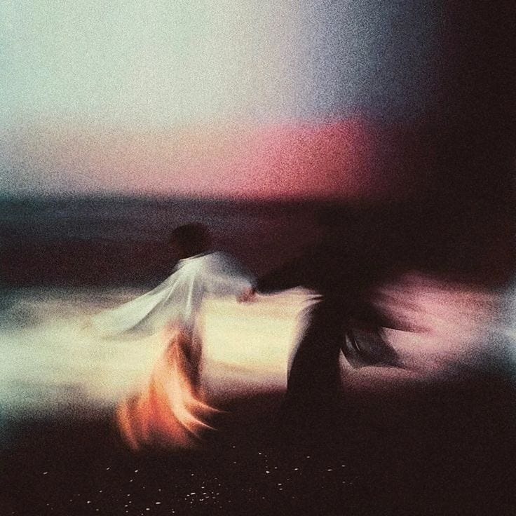 This may contain: blurry photograph of two people walking on the beach