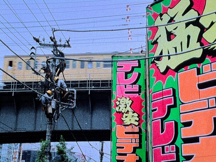 Still images from Tokyo Melody: Sakamoto playing piano, images of Tokyo subway system, street crossing, and utility workers.