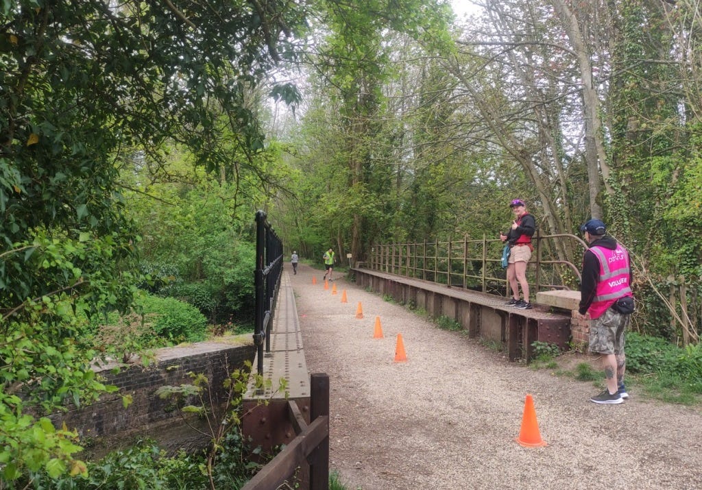 Cones down the middle of the path at the out and back section, which starts here, on a bridge with girders holding up the railings at the side.