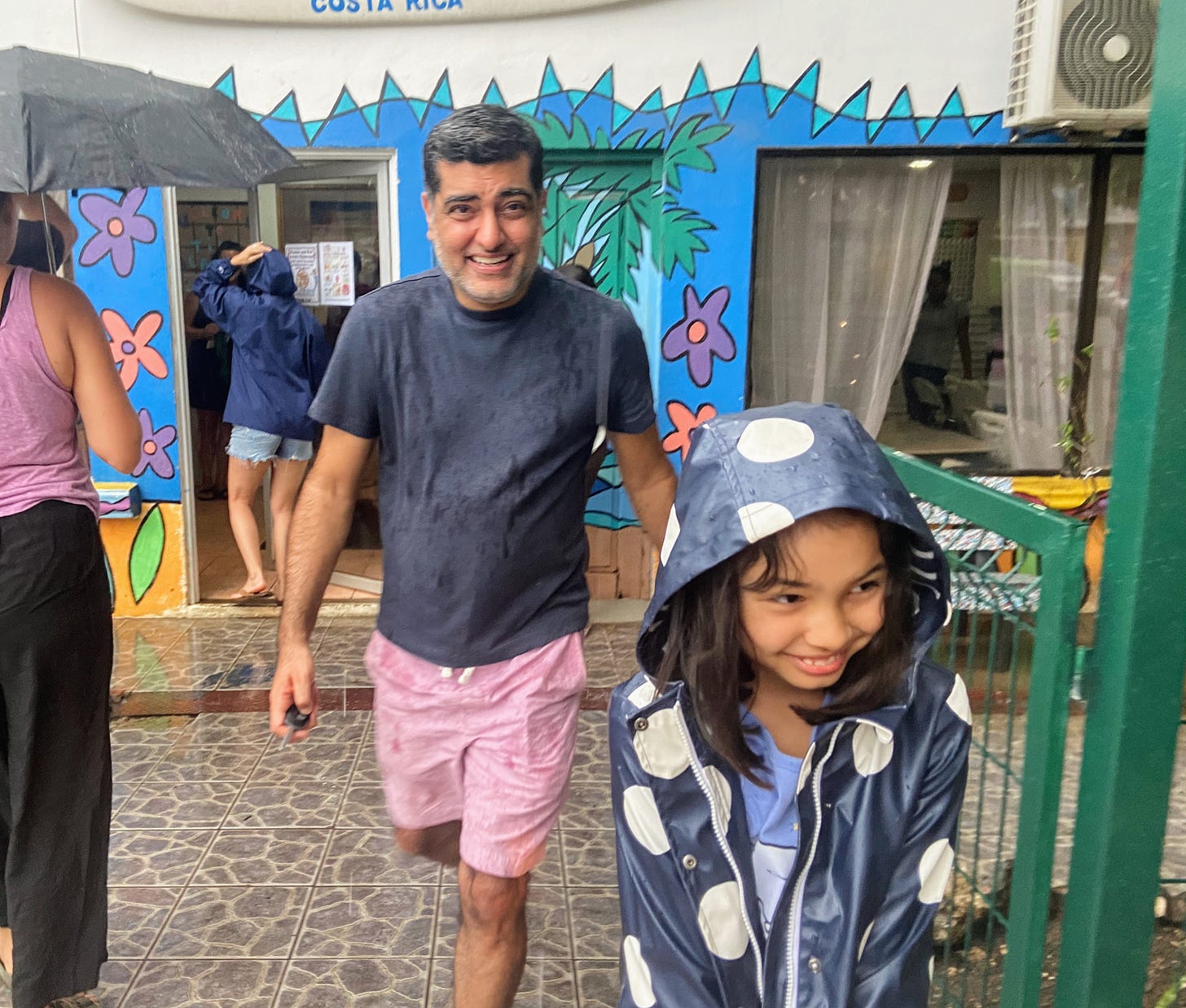 man and girl leaving school in the rain