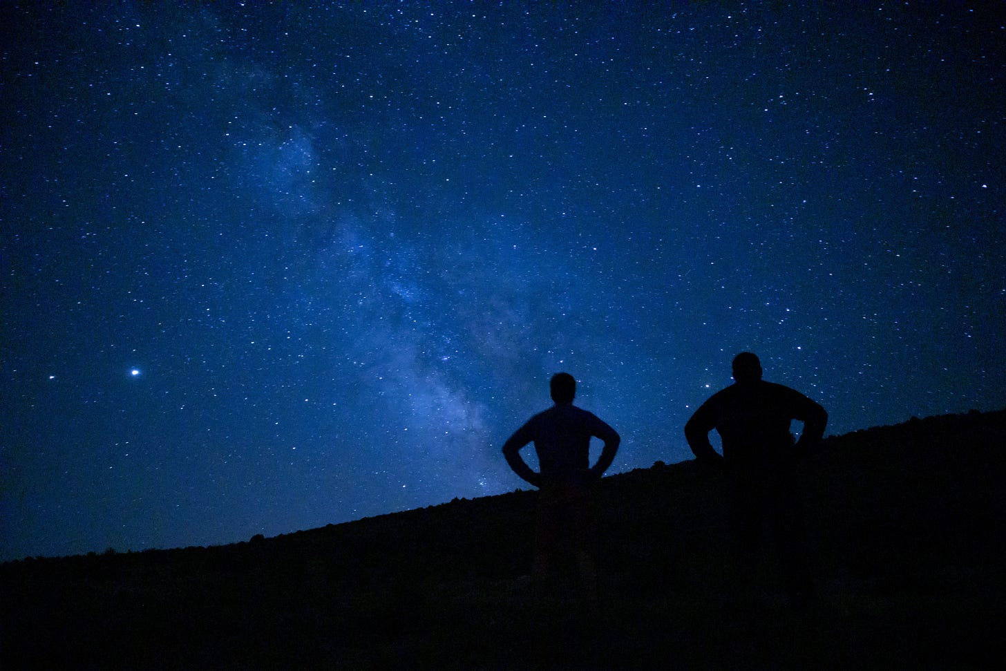 2 People under the milky way looking up at it