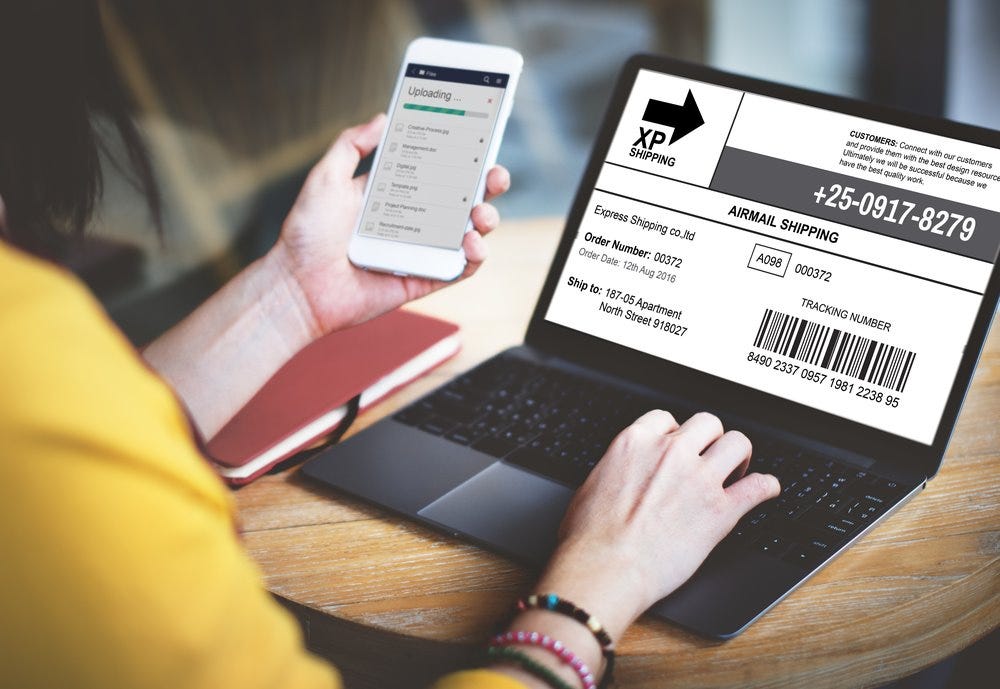 A person holding a phone and a computer

Description automatically generated