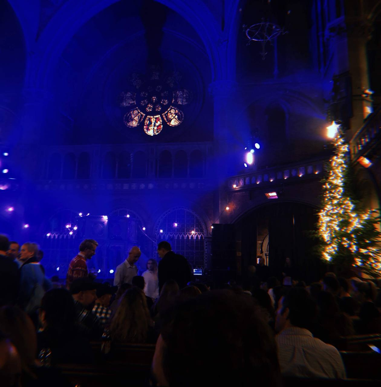 A blurry, atmospheric photo of the interior of a chapel, decked in Christmas decor and fairy lights
